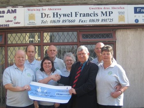 Dr Hywel Francis and President of the Epilepsy Group, at his constituency office where he presented them with the Cheque