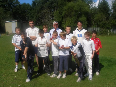 Dr Francis (centre) with Coaches Mark Cox (Left) and Gareth Evans (right) along with members of the Cricket Summer School